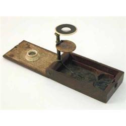 A late 19th century small botanical microscope, with turned bone lens surmounted in a gilt brass...