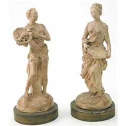 A pair of terracotta statuettes, of a male and female fruit picker, each semi draped on cushion b...