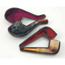 Two meerschaum pipes, one carved as an animal claw clasping the main tobacco chamber with silver...