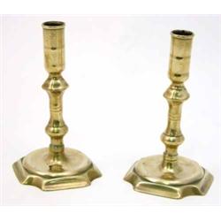 A near pair of George III cast brass candlesticks, with double knopped stems on shaped square bas...