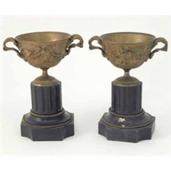 A pair of gilt brass twin handled urns, cast with laurel leaves and fruiting vines on reeded slat...