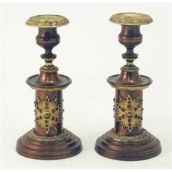 A pair of bronzed metal candlesticks, with gilt metal sconces above a knopped stem and supported...