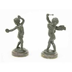 A pair of late 19th century bronze figures of putti after Clodion, one holding a pair of hand pad...