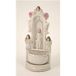 A Victorian Staffordshire holy water font, moulded with the figure of Christ surrounded by angels...