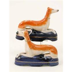 A pair of French porcelain greyhound inkstands, each lying on oval blue-painted base with quill r...