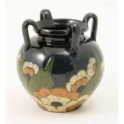 A four-handled terracotta vase, primitively decorated with flowers and leaves in sgraffito, 7.25i...