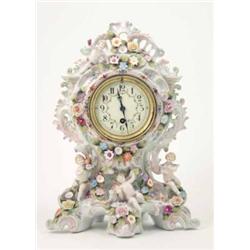 A late 19th century Dresden porcelain mantel timepiece, encrusted with flowers and putti, 15ins...