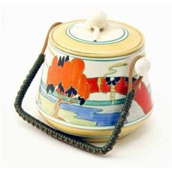 A Clarice Cliff ‘Solitude’ biscuit barrel and cover, a design of orange-leaf trees and stylised l...