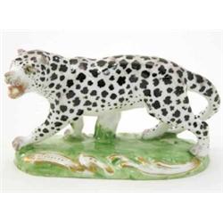 A 19th century porcelain leopard model, painted with black markings, on scroll-moulded oval base,...