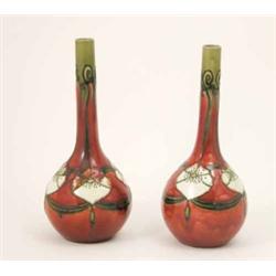 A pair of Minton Secessionist vases, globe and shaft form tubed with stylised foliage against a p...