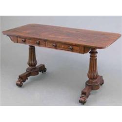 A Regency rosewood writing table, with opposing real and dummy drawers, on reeded baluster end st...