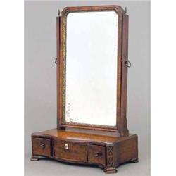 An early George III mahogany serpentine toilet mirror, with blind fret angles and three drawers o...