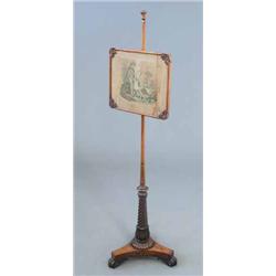 A Regency rosewood pole screen with embroidered panel on spiral fluted column and triform base...