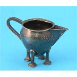 An Arts and Crafts hammered silver cream jug, makers; David & Maurice Davis, Birmingham 1905, 3in...