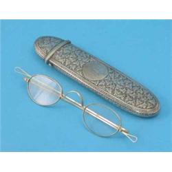 A Victorian silver spectacles case, with engraved ivy decoration and a pair of spectacles...