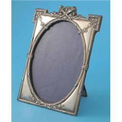An Edwardian silver photograph frame, of rectangular form with trophy crest and oval aperture, Bi...