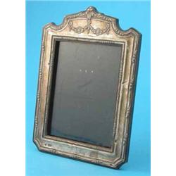 A George V silver photo frame, of shaped rectangular form, decorated with flowers, Chester 1913,...
