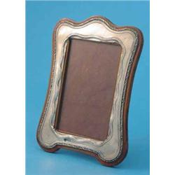 A George V silver photo frame, of serpentine rectangular form, Birmingham 1913, 7.75ins...