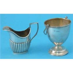 A George V silver sugar basket, Chester 1915, and a demi-fluted cream jug...
