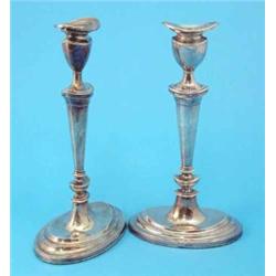 A pair of silver candlesticks with oval sconces, tapered stems and loaded feet, 1964, 11.5 ins....