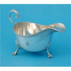 An Edwardian silver sauceboat with flying scroll handle, 7 oz....