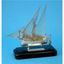 A Maltese white metal model of a fishing boat on ebonised plinth with presentation inscription, 1...