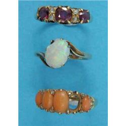 An 18ct gold crossover ring, claw-set with an oval opal, a garnet and diamond half hoop ring and...