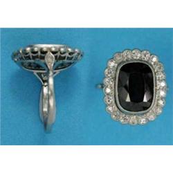 A sapphire and diamond tablet ring, the cushion shaped sapphire in a border of 22 millegrain set...