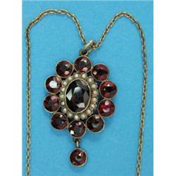 A gold garnet and seed pearl oval cluster pendant, with matching drop, on gold tracelink chain...