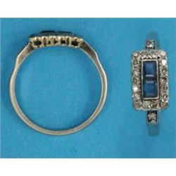 An 18ct white gold Art Deco cluster ring, set 2 calibre-cut sapphires bordered by a row of diamon...