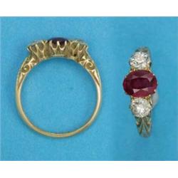 An 18ct gold 3-stone ring, claw set with an oval synthetic ruby flanked by diamonds...