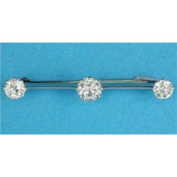 An Edwardian brooch, claw-set with 3 diamonds on a knife edge bar, the centre stone approximately...
