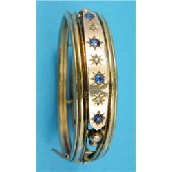 A Victorian gold openwork hinged bangle, the front gypsy-set with 4 sapphires and 3 diamonds...