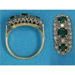 An 18ct gold emerald and diamond cluster ring, set 3 round cut emeralds in a border of diamonds...