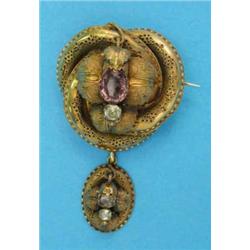A Victorian bloomed gold entwined knot brooch, with wirework decoration set with an amethyst supp...