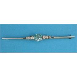 An 18ct gold bar brooch, claw-set with a blue zircon flanked by 6 diamonds...