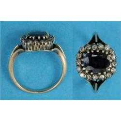 A gold sapphire and diamond cluster ring, the cushion shape sapphire bordered by a row of 17 diam...