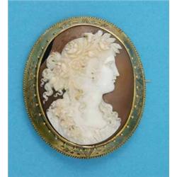 A Victorian shell cameo brooch, carved with a classical female profile, in an engraved and bead d...