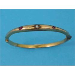 A 15ct gold hinged bangle, the front gypsy set with a diamond and 2 rubies...