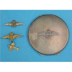 A silver circular engine turned powder compact, with enamel RAF insignia and 2 RAF lapel brooches...