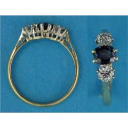 An 18ct gold 3-stone ring, set with an oval sapphire flanked by brilliant cut diamonds...