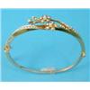 Image 1 : A gold hinged bangle, the front designed as two sprays of flowers set split pearls...