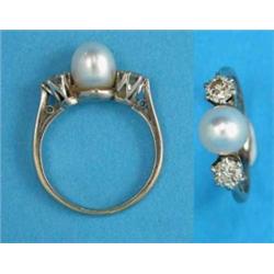 A white gold ring, set with a pearl, flanked by 2 claw-set brilliant cut diamonds...