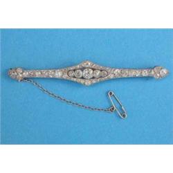 An Edwardian all diamond bar brooch, millegrain set with a centre row of 5 diamonds, bordered by...