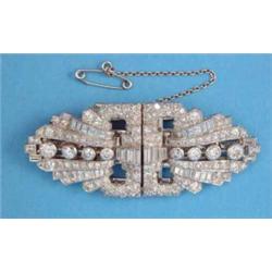 A 1930’s white gold all diamond set brooch/dress clip, of stylised buckle shape set brilliant and...