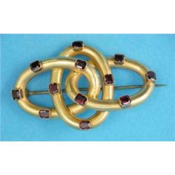 A Victorian bloomed gold brooch, designed as 3 entwined oval links set rectangular garnets...
