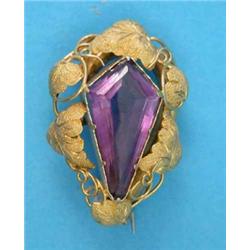 A Victorian gold brooch, set with a kite shape amethyst, in a vine leaf frame...