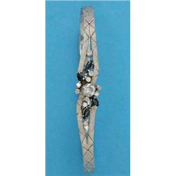 An 18ct textured white gold flexible bracelet, the crossover front set with a spray of brilliant...