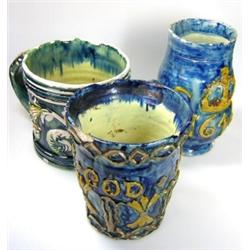 Three blue mugs, 'No.57', 'Feare God 1630', 14cm high, 'No.32', 'CR 1646', 17cm high and a mask and.