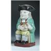 Image 1 : An early 19th century pearlware toby jug, he sits clasping a foaming mug of 'Stout' and wears a gre.